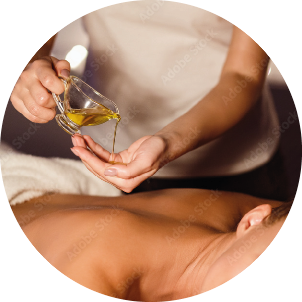 Phto d&#039;un masseur faisant couler de l&#039;huile de massage dans sa main au-dessus de la massée